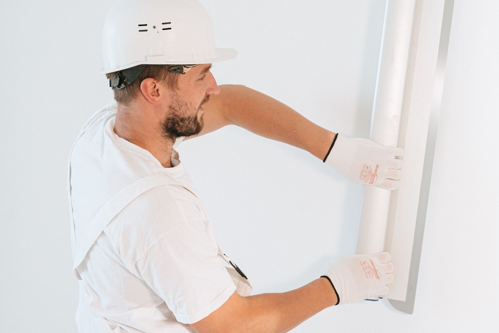 Worker installing new drywall during reconstruction in Plano, TX