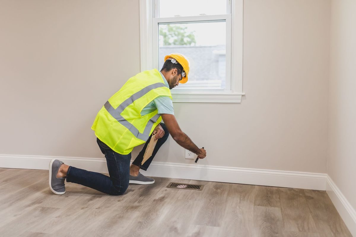 Restoration technician inspecting a wall corner for hidden moisture in Plano, TX